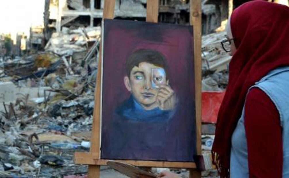 Jóvenes sirios pintan entre las ruinas de la guerra