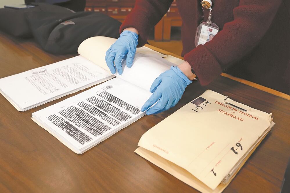 Ayer, en el primer día de consulta, una trabajadora mostró documentos de la DFS en su versión pública y otra versión con protección de datos personales. Fotos: BERENICE FREGOSO. EL UNIVERSAL