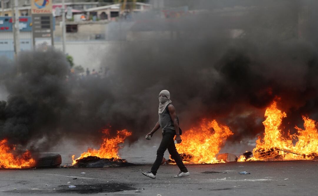 Un manifestante pasa junto a una barricada en llamas durante protestas antigubernamentales en Puerto Príncipe, Haití - Foto: Iván Alvarado/REUTERS