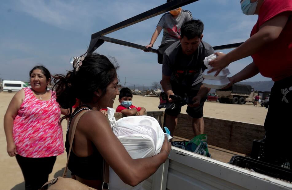 Personas damnificadas en el campamento irregular reciben almuerzos, tras los incendios del día viernes 2 de febrero, en la zona de Viña del Mar, Región de Valparaiso. Foto: EFE