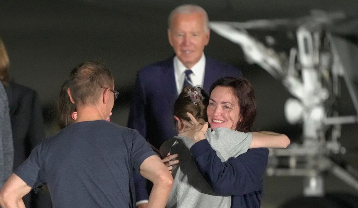 El presidente Joe Biden observa cómo Alsu Kurmasheva abraza a un miembro de su familia en la pista después de llegar a la Base de la Fuerza Aérea Andrews, Maryland. Foto: Manuel Balce Ceneta. Foto: AP