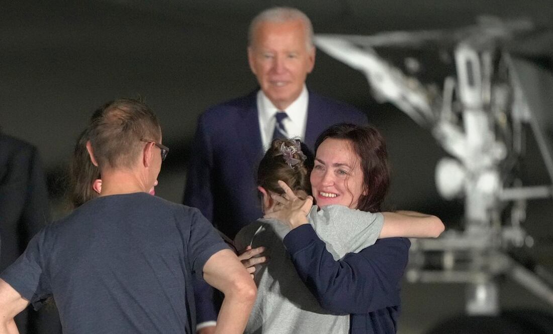 El presidente Joe Biden observa cómo Alsu Kurmasheva abraza a un miembro de su familia en la pista después de llegar a la Base de la Fuerza Aérea Andrews, Maryland. Foto: Manuel Balce Ceneta. Foto: AP