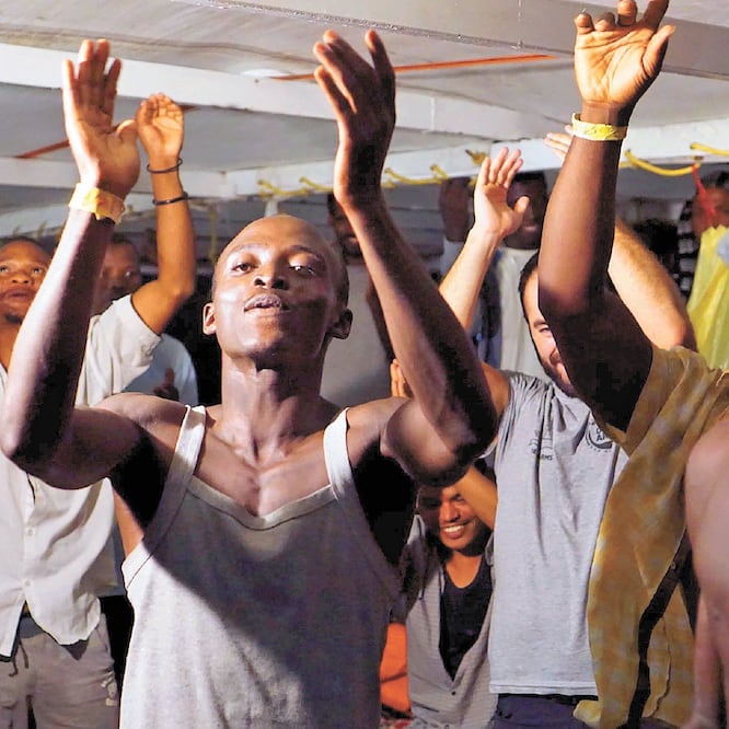 Migrantes, a bordo del Open Arms, celebran la orden para que al fin pudieran desembarcar en Lampedusa. FRANCISCO GENTICO. AP