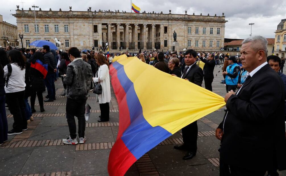 Simpatizantes del fallecido senador y precandidato presidencial Miguel Uribe Turbay extienden una bandera de Colombia este miércoles, en la Plaza de Bolívar en Bogotá (Colombia). Con una misa solemne en la Catedral Primada y honores militares, Colombia dio un adiós multitudinario a Uribe Turbay. (13/08/25) Foto: EFE