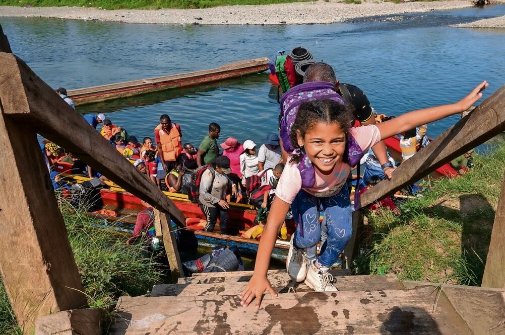 Una niña migrante irregular sonríe al culminar en 2023 un tramo del recorrido del peligroso Tapón del Darién, en el oriente de Panamá. Foto: Unisef