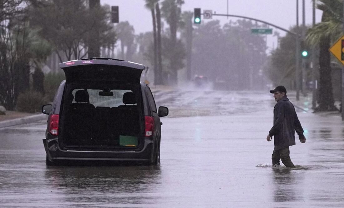 Un conductor acude a retirar pertenencias de su vehículo tras quedar varado en una calle inundada en Palm Desert, California. Foto: AP