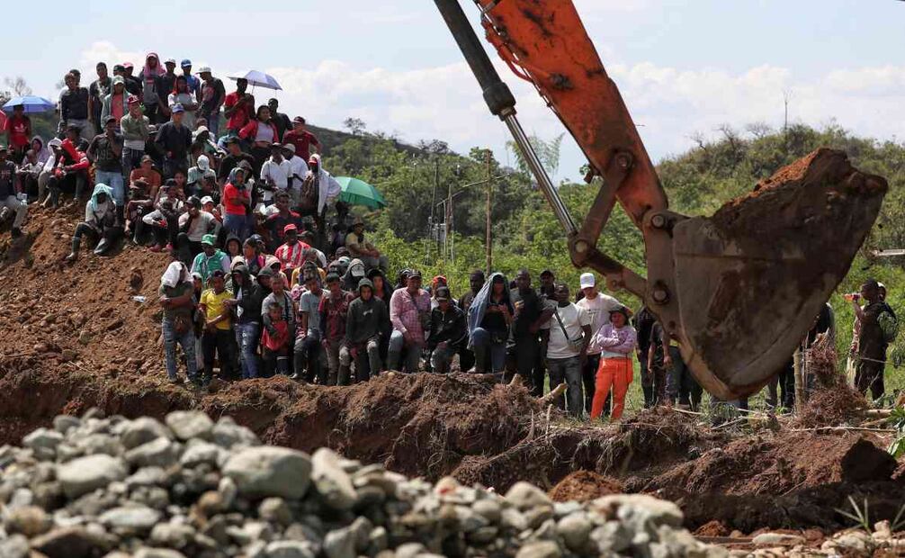 Amigos y familiares de mineros atrapados observan la maquinaria que busca sobrevivientes en una mina de oro no autorizada que se derrumbó en Santander de Quilichao, Colombia, el viernes 12 de septiembre de 2025. Foto: AP