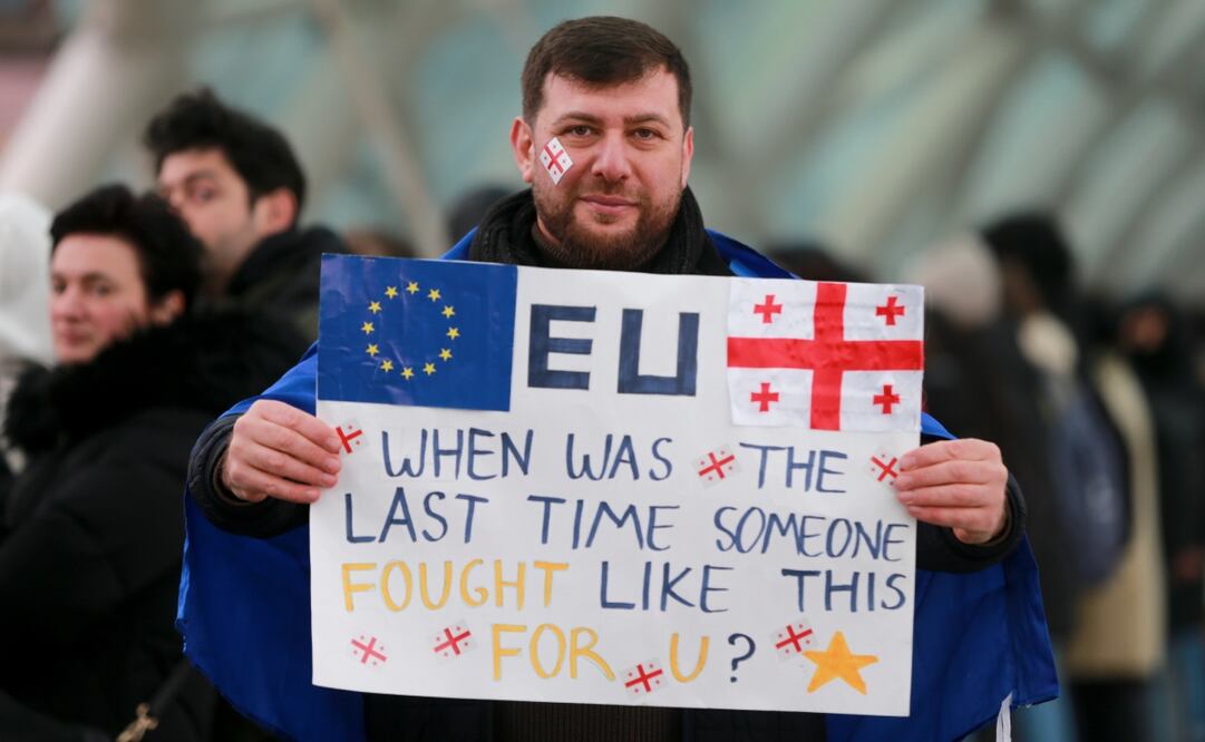 Un manifestante sostiene un cartel mientras se alinea en cadena durante una manifestación antigubernamental frente al edificio del Parlamento en Tbilisi, Georgia, este sábado. Foto: AP