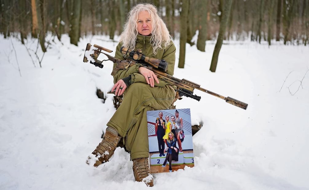 Tetiana Khimion, de 47 años, ahora francotiradora del ejército, posa con una fotografía suya como profesora de baile, tomada antes de la guerra. Foto: Sergei Grits / AP