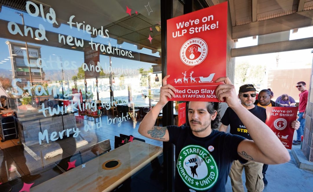 Baristas de Starbucks durante las protestas afuera de una sucursal de la cadena de cafeterías en Burbank, California. Foto: Damian Dovarganes | AP (23/12/2024)