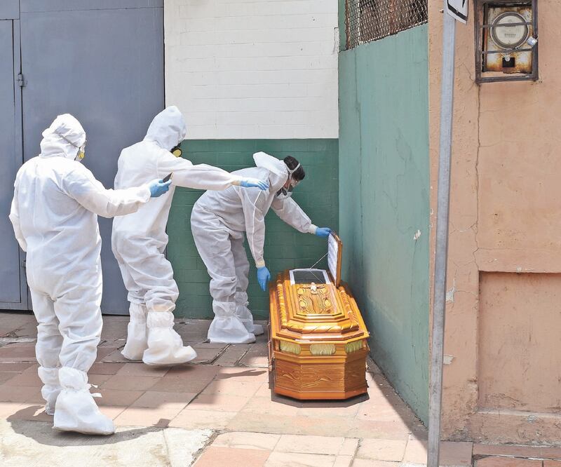 Una brigada usa trajes protectores al manejar un ataúd de una persona que falleció por coronavirus, en Guayaquil, Ecuador. Foto: EDISON CHOCO. AP