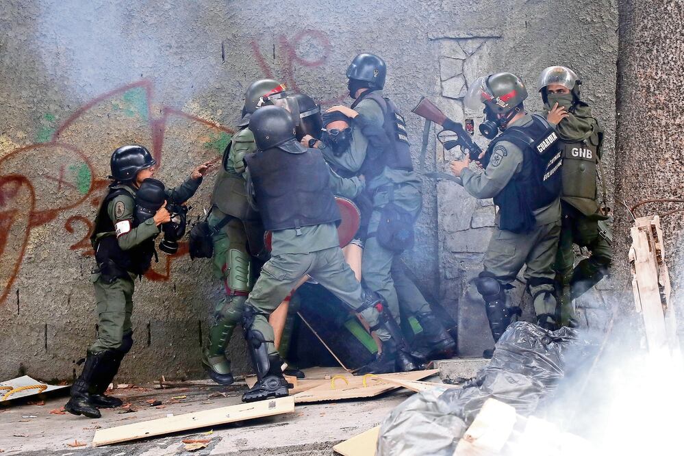 Policías acorralan a un manifestante en Caracas, durante la primera jornada del paro cívico de 48 horas convocado contra la Constituyente (CARLOS GARCÍA RAWLINS. REUTERS)