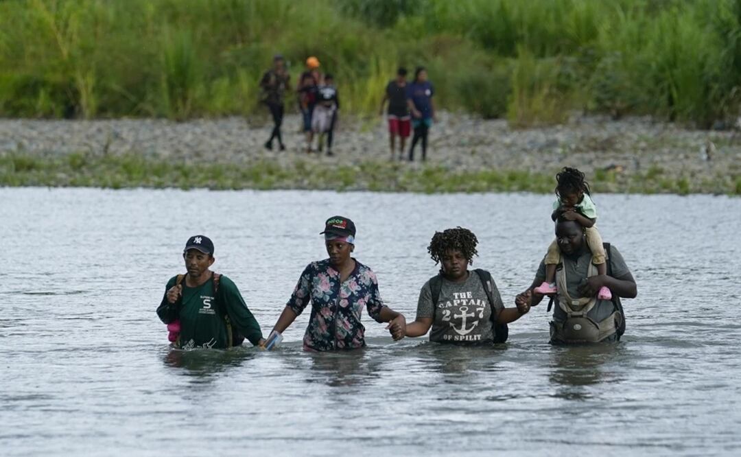 Migrantes haitianos vadean el río Tuquesa después de caminar por el Tapón del Darién, el miércoles 4 de octubre de 2023, en Bajo Chiquito, Panamá. Foto: AP