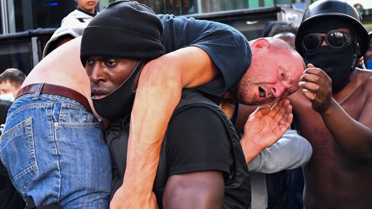La foto de Patrick Hutchinson (centro) cargando un manifestante se volvió viral (Foto: Reuters)
