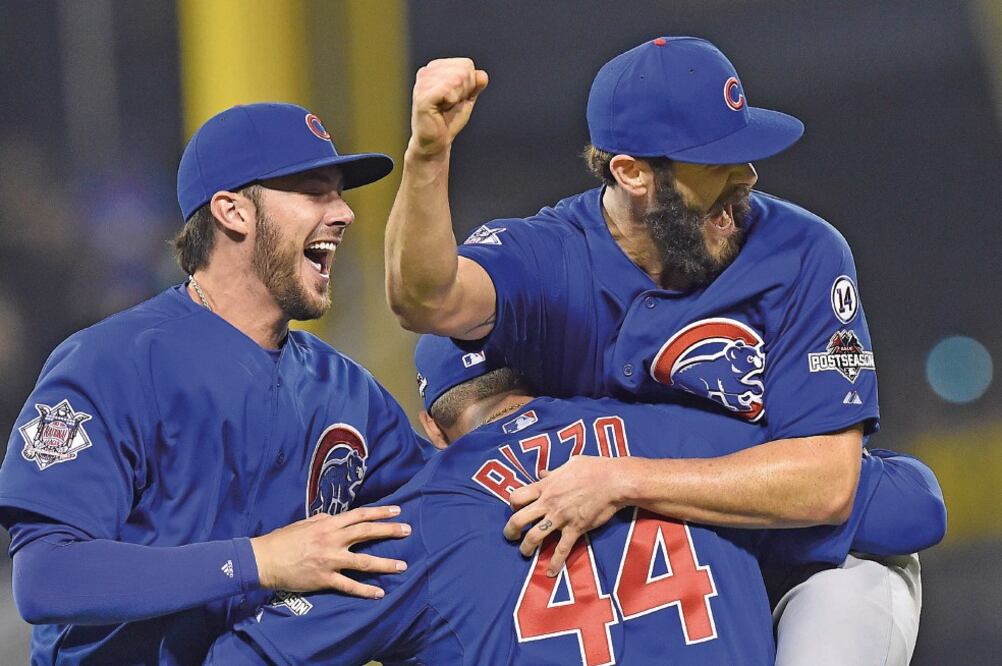 El pitcher de los Cubs, Jake Arrieta, maniató a la poderosa ofensiva de los Pirates para ganar el Wild Card de la Liga Nacional y es felicitado por sus compañeros (DON WRIGHT. AP)