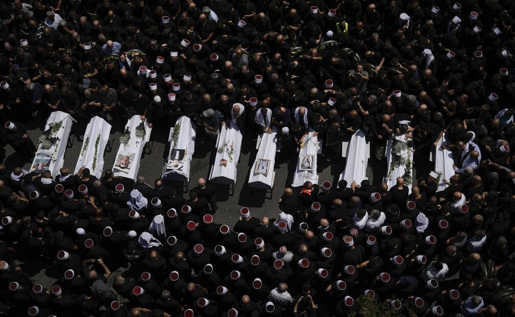 Dolientes rodean los cuerpos de algunos de los 12 niños y adolescentes asesinados en un ataque de cohete contra un campo de fútbol en la localidad de Majdal Shams. Foto: AP