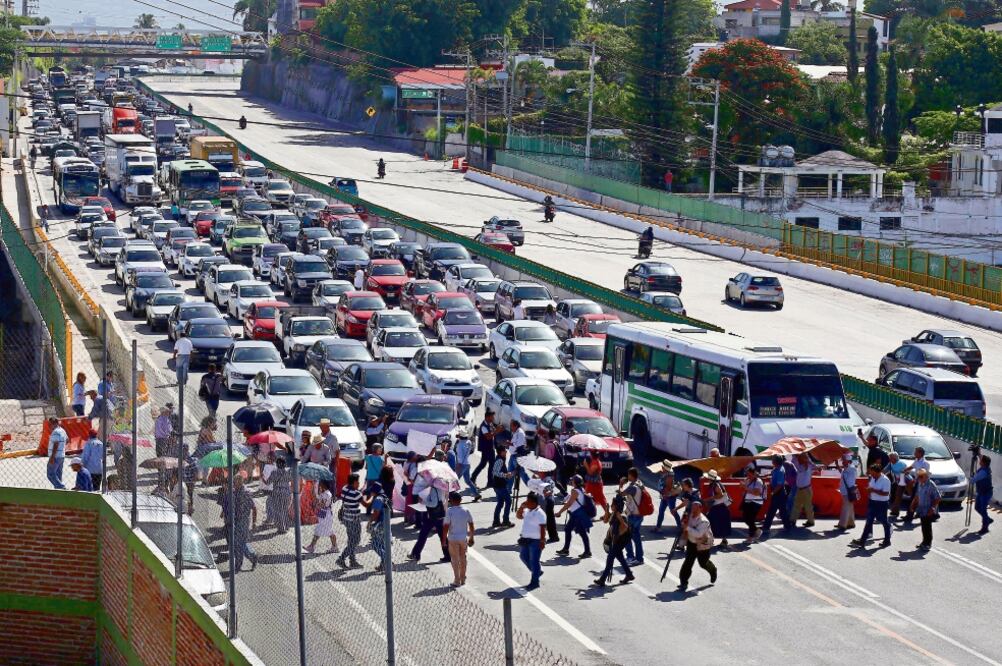 La asociación Gustavo Salgado bloqueó por diez minutos el Paso Exprés, el tramo donde hace un año murieron padre e hijo, al abrirse un socavón y caer en su auto. Se guardó un minuto de silencio por las víctimas de esta obra realizada por la SCT. (CUARTOS)