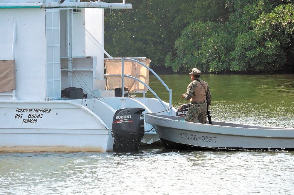 Un elemento de la Marina observa la embarcación en la que un grupo de turistas realizaban un paseo en el municipio de Paraíso. Foto/CORTESÍA RUBÉN LÓPEZ