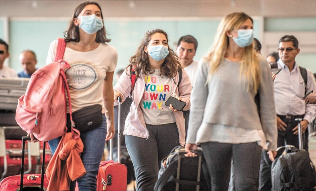 Passengers walk while wearing protective masks, as a preventive measure regarding the COVID-19 virus – Photo: Ernesto Benavides/AFP