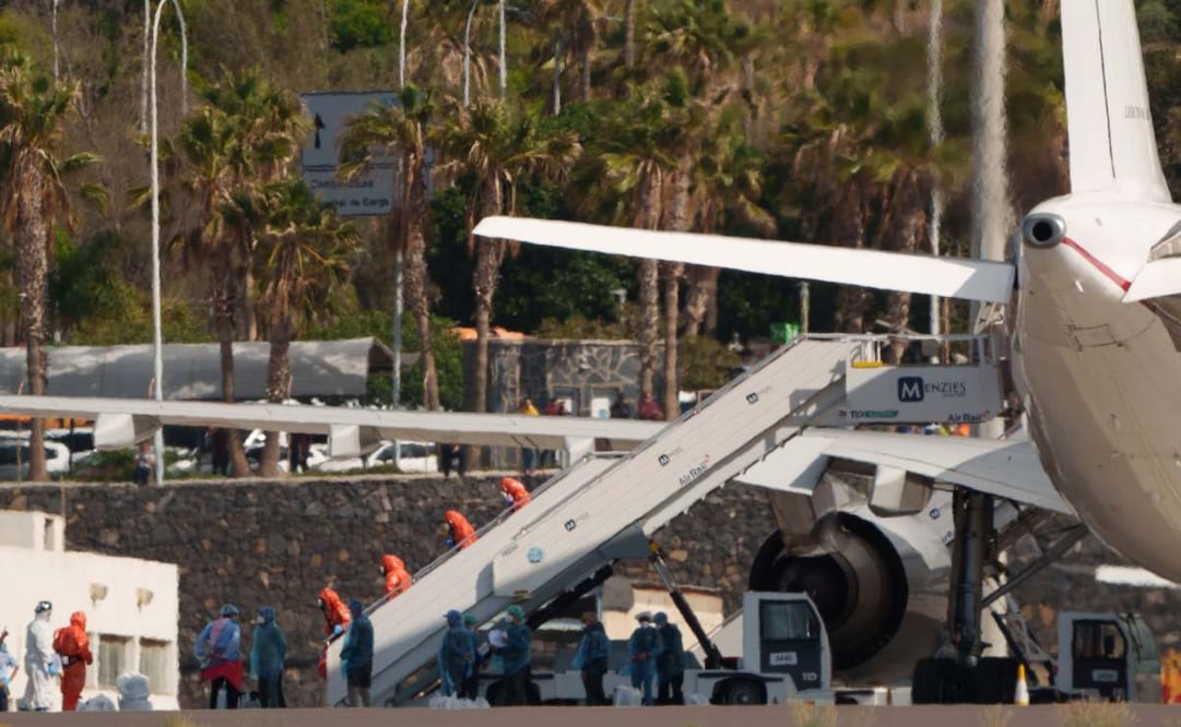 Los catorce pasajeros españoles que iban a bordo del crucero que ha sufrido un brote de hantavirus durante su travesía por el Atlántico Sur, el MV Hondius, han embarcado en el aeropuerto de Tenerife Sur en el avión del Ejército del Aire que los trasladará a Madrid, para iniciar un periodo de cuarentena en el Hospital Gómez Ulla. En la imagen, miembros de la Unidad Militar de Emergencias con trajes de protección en la escalerilla de la aeronave. Foto: EFE