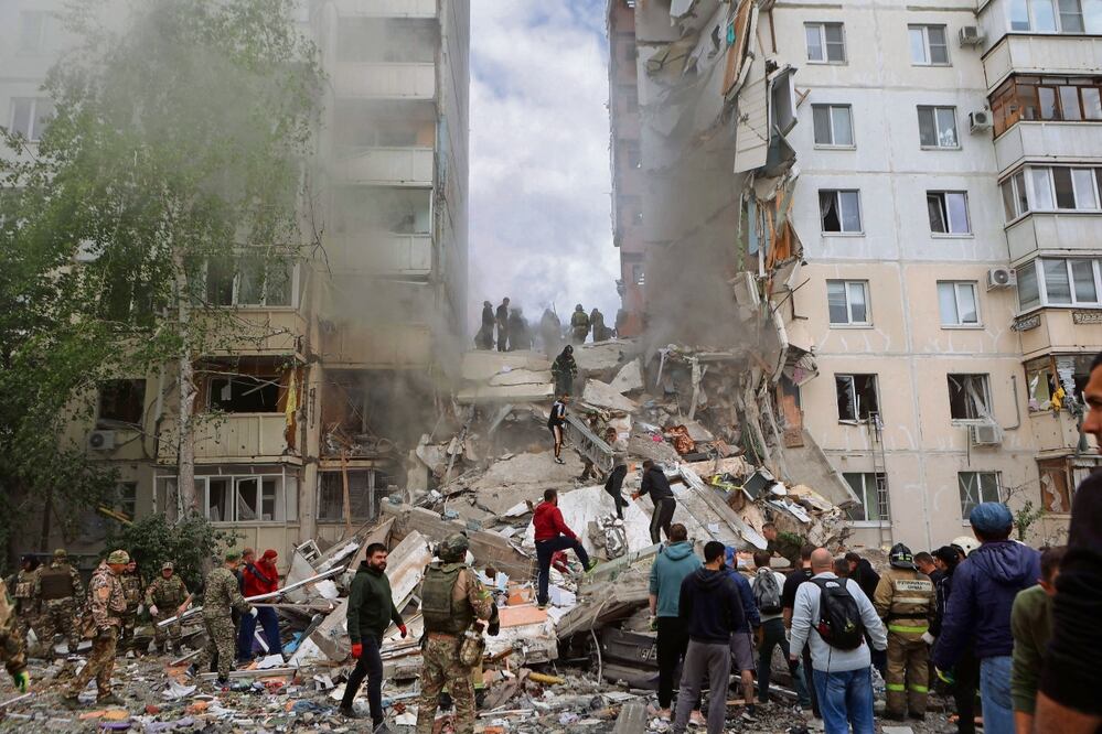 Bomberos y voluntarios operan para asegurar en un área de departamentos colapsados tras un ataque ucraniano en Belgorod. Foto: AFP
