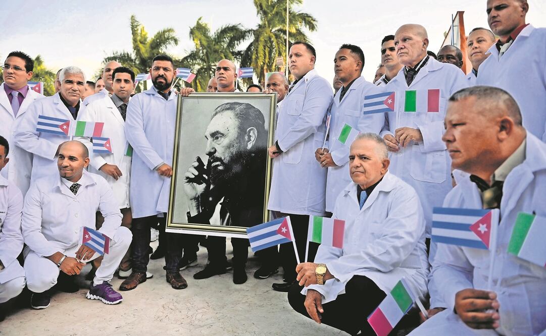 Médicos y enfermeras de la Brigada Médica Internacional Henry Reeve de Cuba, con un retrato del difunto líder revolucionario Fidel Castro, en su despedida antes de viajar a Italia para ayudar en la lucha contra la pandemia por Covid-19 en marzo de 2021.