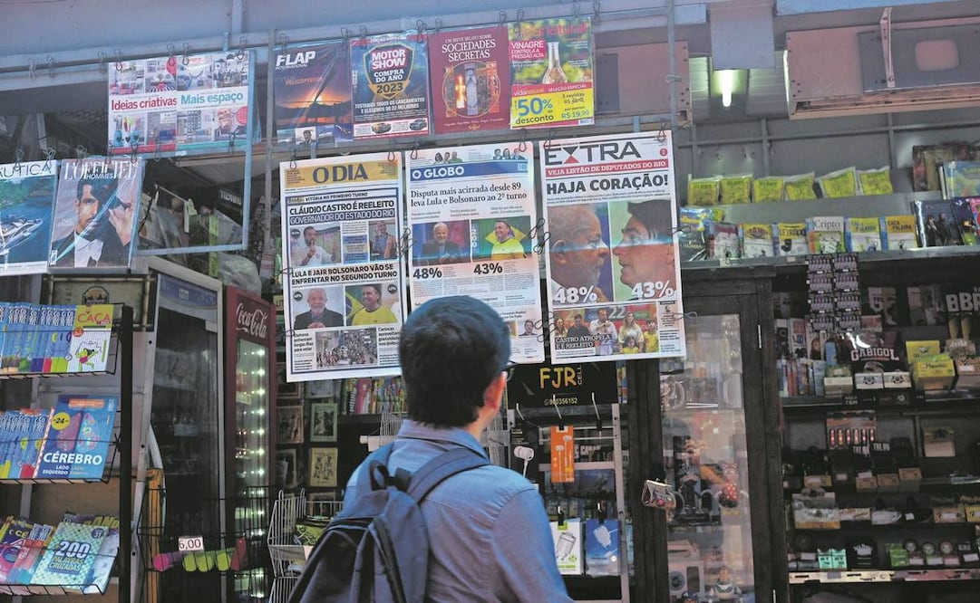Un brasileño mira en Río de Janeiro las portadas de los periódicos, que dan cuenta del resultado de la jornada electoral del domingo. Foto: Mauro Pimentel/ AFP.
