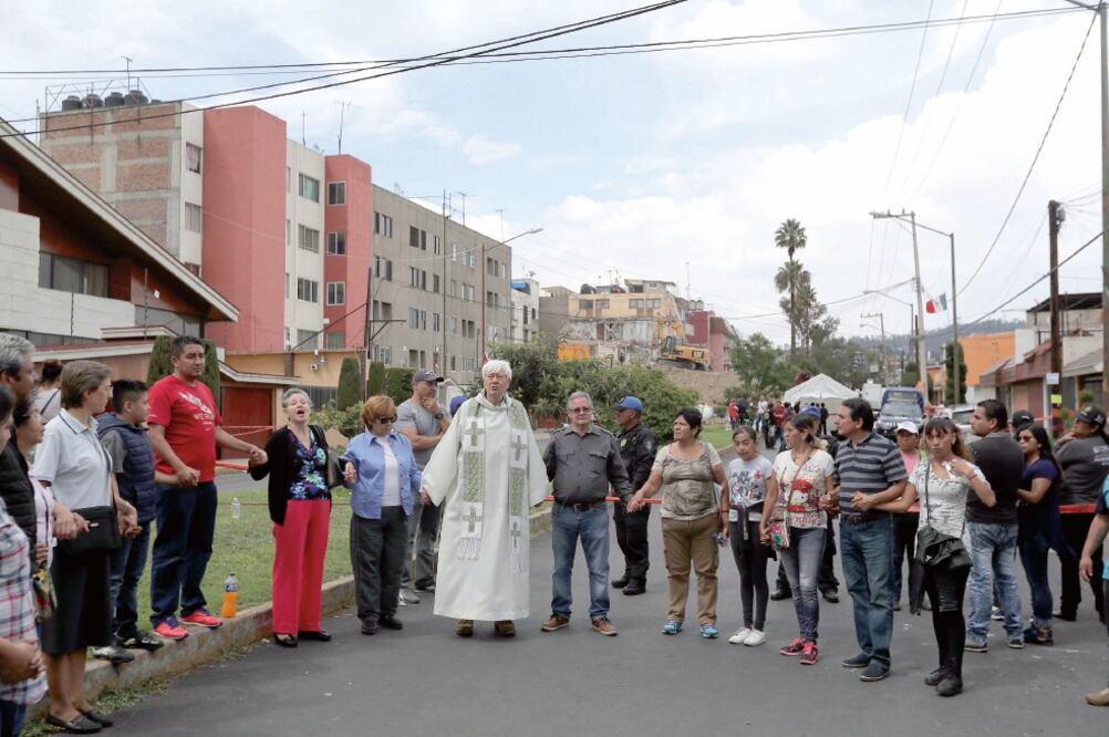 Habitantes de Paseo de Las Galicias, en Iztapalapa, oraron por una familia cuyos cuerpos fueron rescatados de edificio colapsado (ALEJANDRO ACOSTA. EL UNIVERSAL)