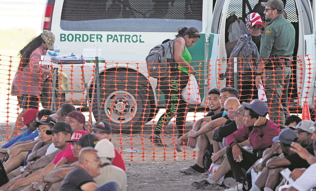 Migrantes que cruzaron el río Grande son retenidos y transportados desde un centro de procesamiento improvisado, en Eagle Pass. Foto: AP