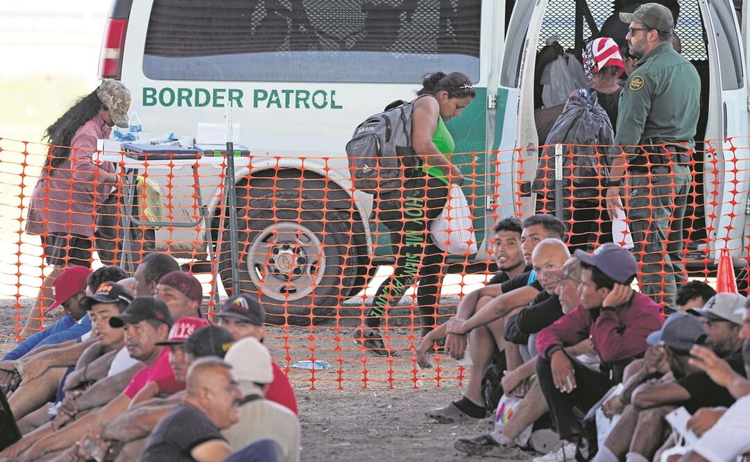 Migrantes que cruzaron el río Grande son retenidos y transportados desde un centro de procesamiento improvisado, en Eagle Pass. Foto: AP