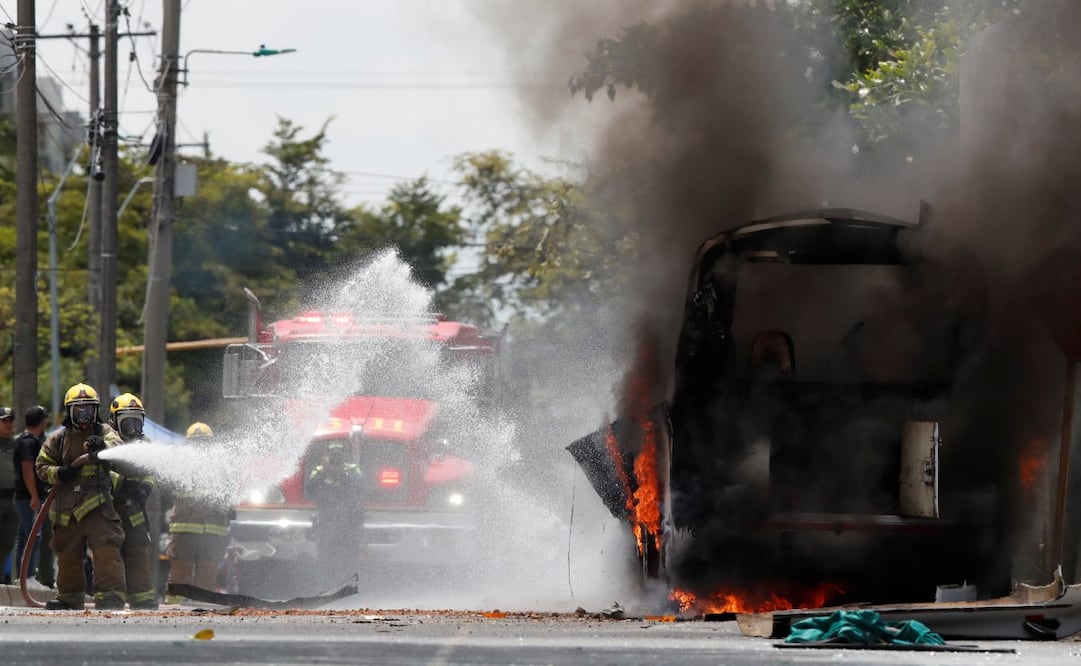 Integrantes del cuerpo de bomberos apagan el fuego en un vehículo afectado por una explosión este viernes, en inmediaciones del batallón de la Tercera Brigada del Ejército en Cali (Colombia). EFE/ Ernesto Guzman Jr
