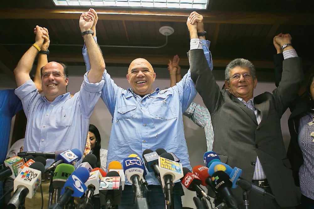 El secretario general de la Mesa de la Unidad Democrática (MUD), Jesús Torrealba (centro) y dos diputados, en su rueda de prensa de ayer en Caracas (FABIOLA FERRERO. EFE)