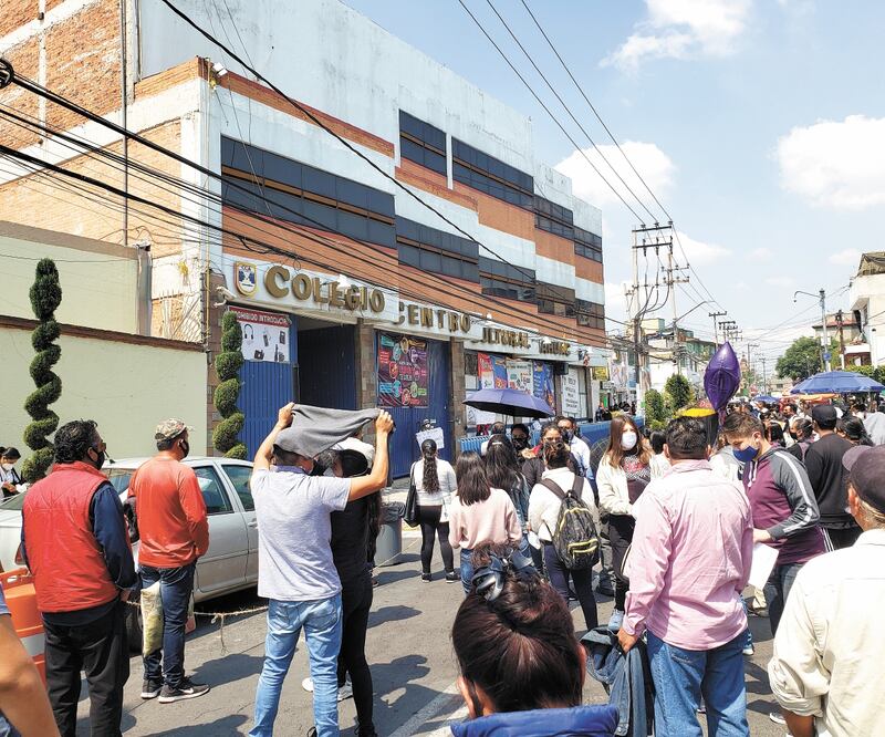 Aun con carteles y con elementos de Protección Civil pidiendo que se respetara el uso de cubrebocas en todo momento, así como evitar las aglomeraciones, padres de familia y acompañantes esperaron afuera del Colegio Anáhuac. Foto: GERMÁN ESPINOSA