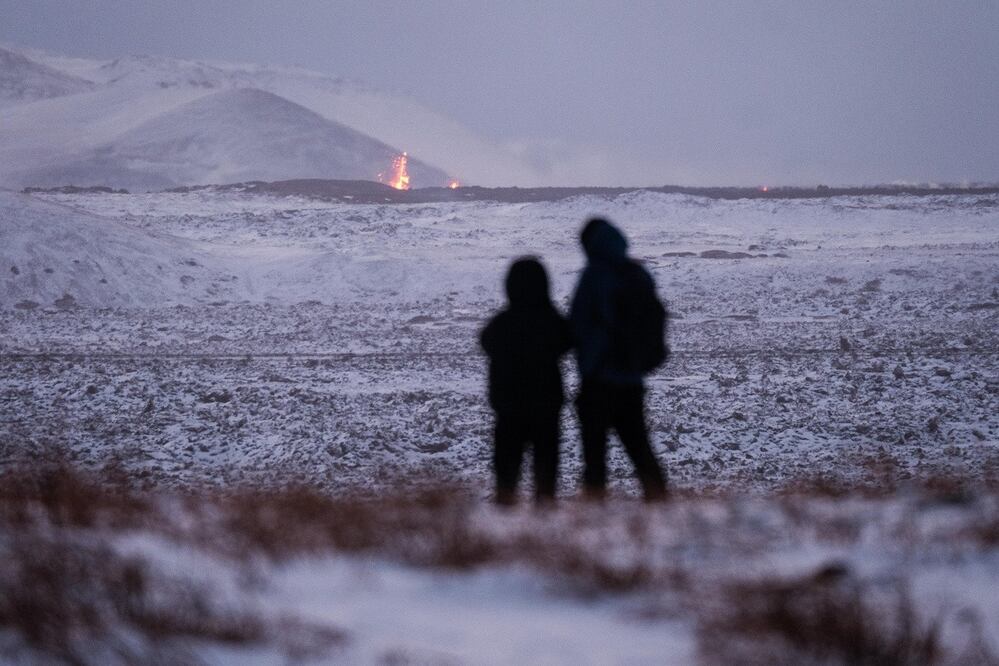 La gente se para a mirar la lava que sale tras la erupción cerca de la localidad de Grindavik, en la península de Reykjanes, en Islandia. FOTO: ANTON BRINK. EFE