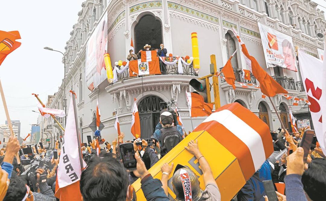 El candidato presidencial Pedro Castillo saluda a sus simpatizantes desde el balcón de su sede de campaña, en Lima. Foto: Guadalupe Pardo. AP