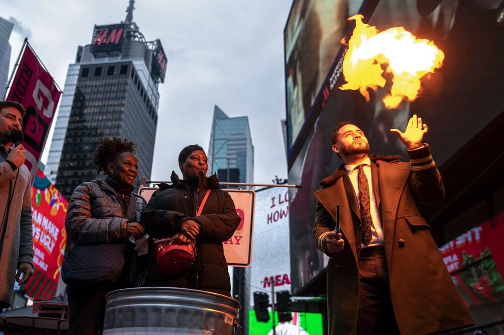 El mago Devonte Rosero, a la derecha, quema notas escritas por personas en Times Square en Nueva York, el jueves 28 de diciembre de 2023. Foto: AP