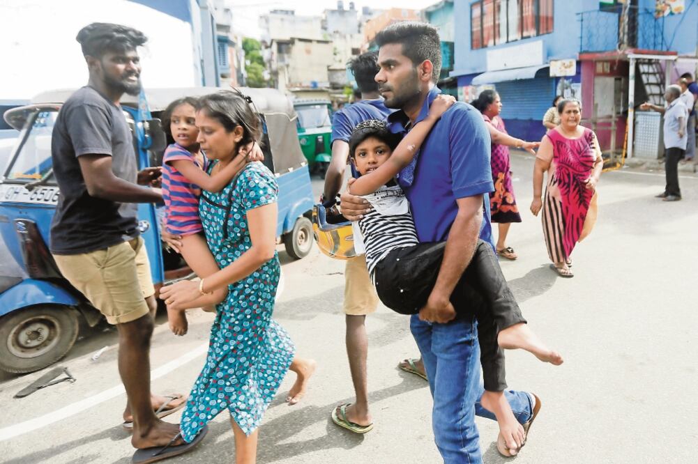 Lugareños huyen ayer de una zona donde el ejército intentaba desactivar un artefacto explosivo colocado en una camioneta que finalmente estalló sin dejar víctimas, en Colombo. / DINUKA LIYANAWATTE. REUTERS 