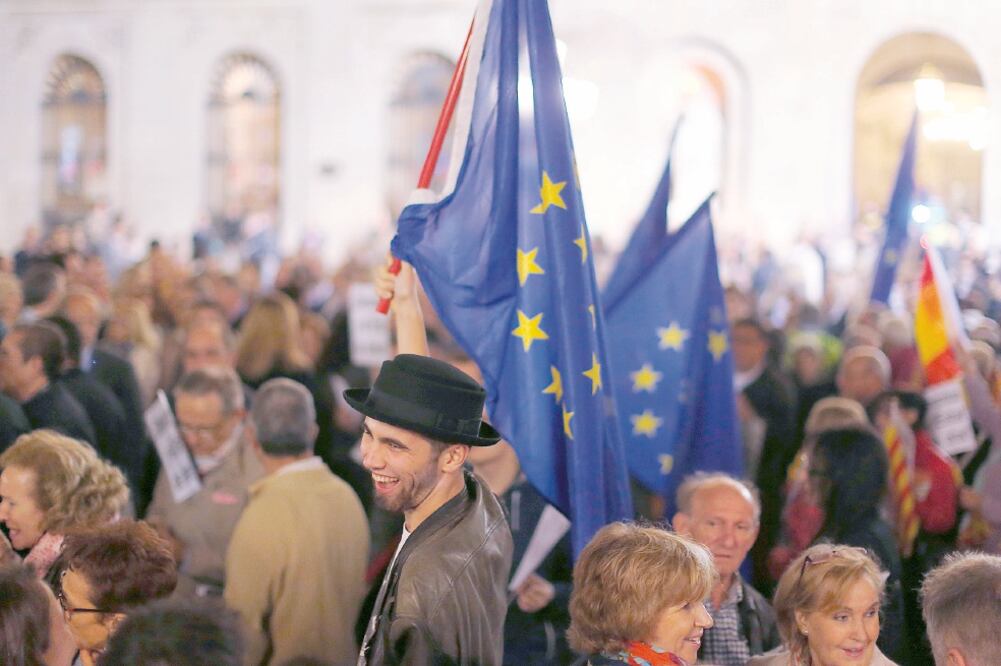 Un hombre sostiene la bandera europea durante la manifestación de este jueves a favor de la “unidad de España”, en Barcelona (MANU FERNANDEZ. AP)