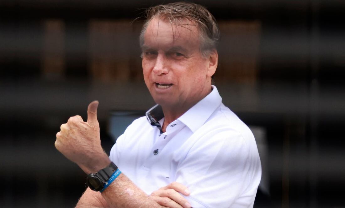 El expresidente brasileño Jair Bolsonaro hace un gesto desde el otro lado de la puerta de entrada de su casa, donde se encuentra bajo arresto domiciliario en Brasilia, Brasil, el martes 2 de septiembre de 2025. Foto: AP
