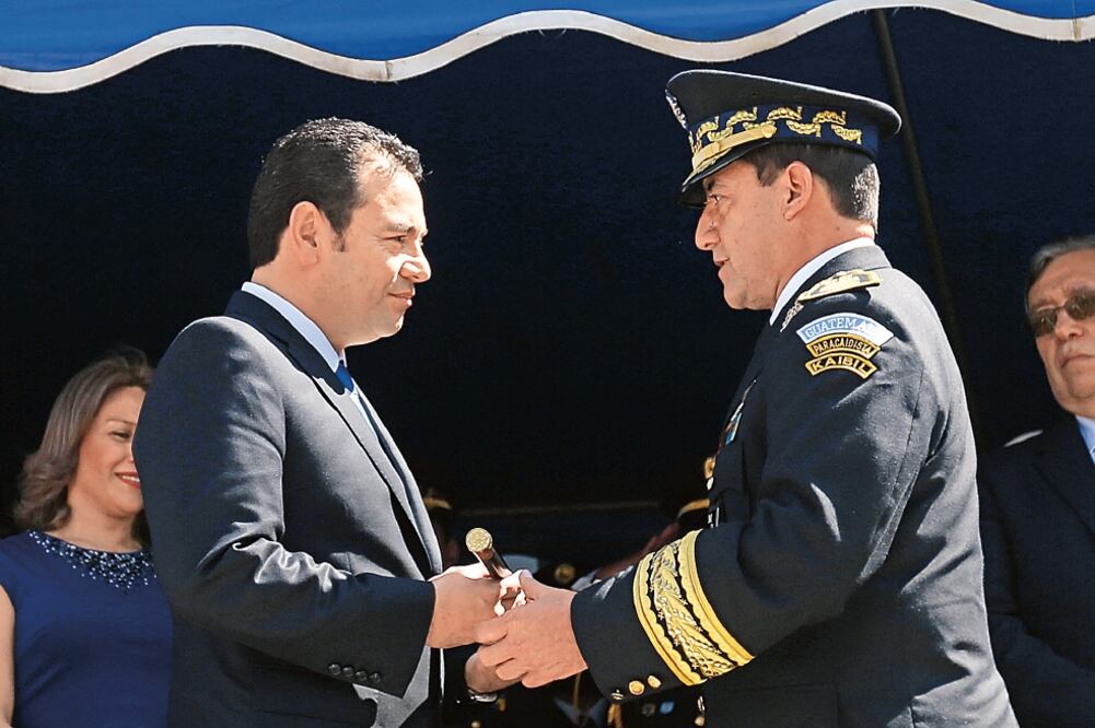 El nuevo presidente guatemalteco, Jimmy Morales, recibe el “Bastón de Mando” de manos del ministro de Defensa, Williams Mansilla, en el Campo de Marte (ESTEBAN BIBA. EFE)