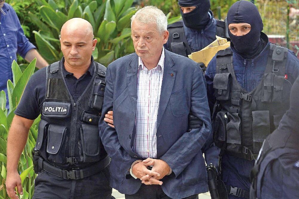 Policías de Rumania escoltan a Sorin Oprescu, alcalde de Bucarest, afuera de su residencia en la villa Ciolpani (MARIUS DUMBRAVEANU. EFE)