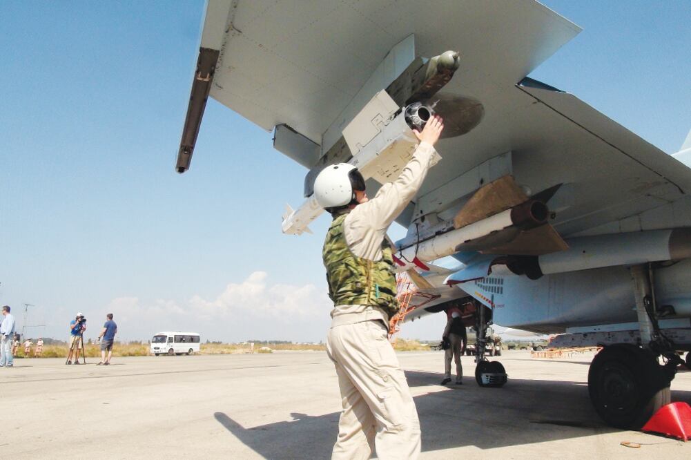 Un piloto ruso acomoda un misil aire-aire en su avión Su-30 antes de despegar de la base aérea de Hmeimim, en Siria (DMITRY STESHIN. AP)