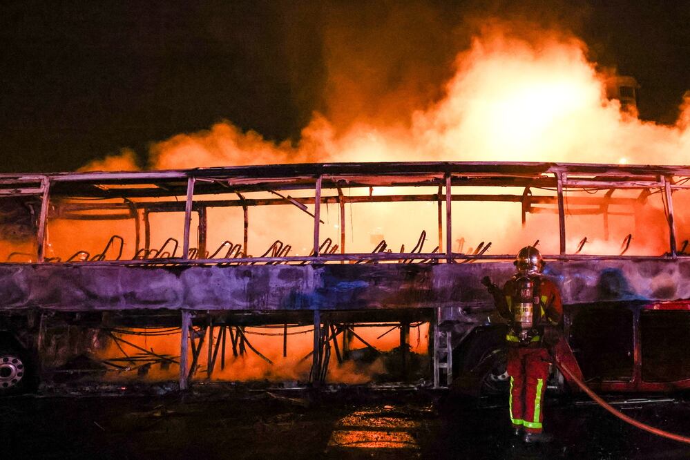 Los bomberos apagan un autobús quemado durante los enfrentamientos entre manifestantes y la policía antidisturbios en Nanterre, cerca de París, Francia, a principios del 1 de julio de 2023. Foto: EFE