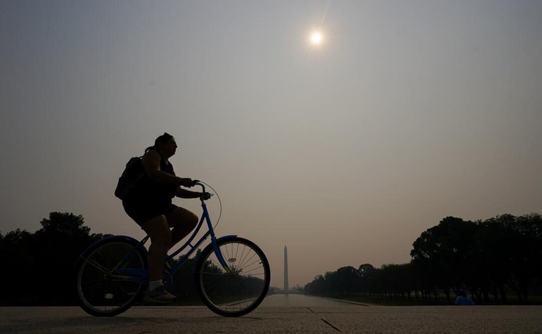 Un ciclista rueda bajo la neblina que cubre la Piscina Reflectante con el Monumento a Washington visto a la distancia, el miércoles 7 de junio de 2023, en Washington. Foto: AP