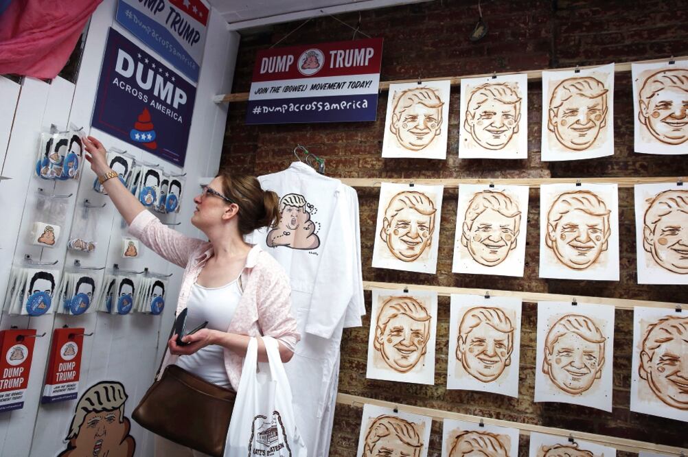 Una mujer observa en una tienda de Nueva York obras del artista urbano Banksy que hacen referencia al virtual candidato republicano para el gobierno de Estados Unidos, Donald Trump (LUCAS JACKSON. REUTERS)