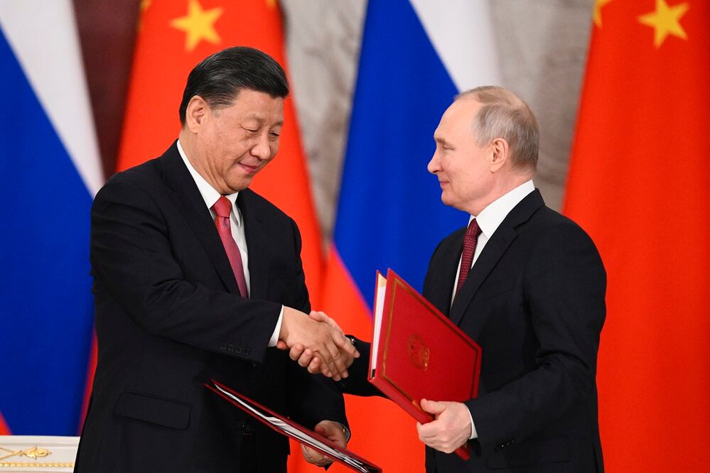 El presidente chino, Xi Jinping, y el mandatario ruso, Vladimir Putin, mientras intercambian documentos, luego de sus conversaciones en el Gran Palacio del Kremlin, en Moscú. Foto: AP