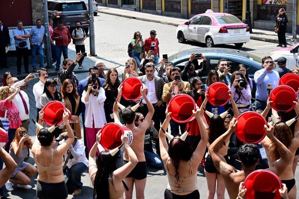 Activistas realizan performance al "bañarse en sangre" en protesta en contra de las corridas de toros. Foto: Especial