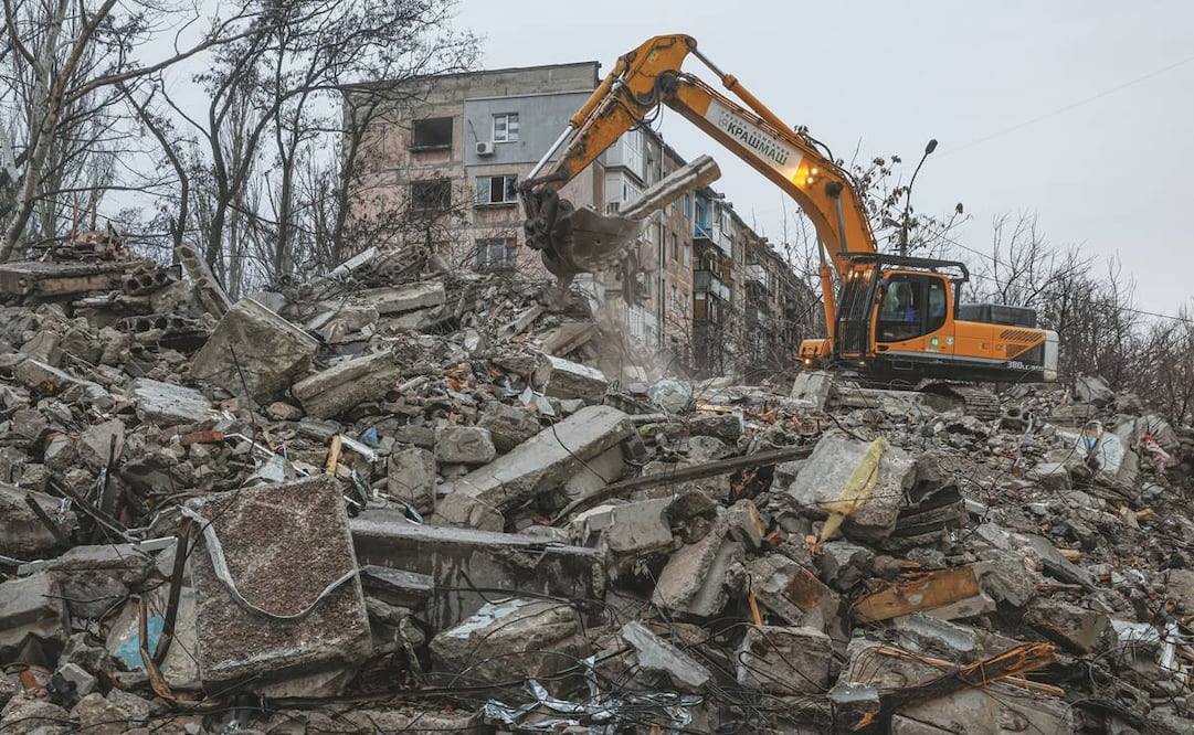 Una excavadora limpia los escombros de un edificio destruido por las fuerzas rusas en la localidad de Mariupol.