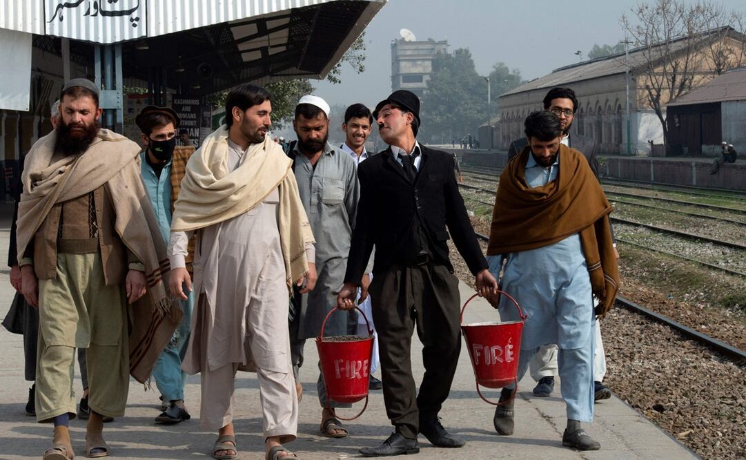 Disfrazado como Chaplin, Usman Khan sortea los "rickshaws"Foto: AFP