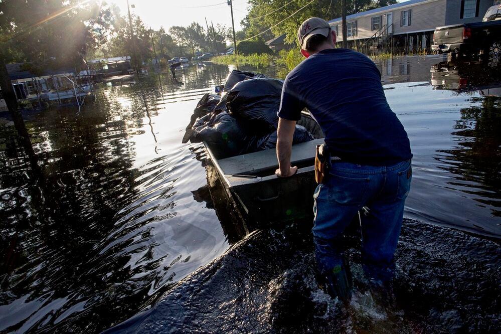 Un hombre salva sus últimas pertenencias en un bote. (AP)